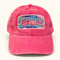 Front view of a hot pink distressed ponytail baseball hat with colorful BALLz embroidery.
