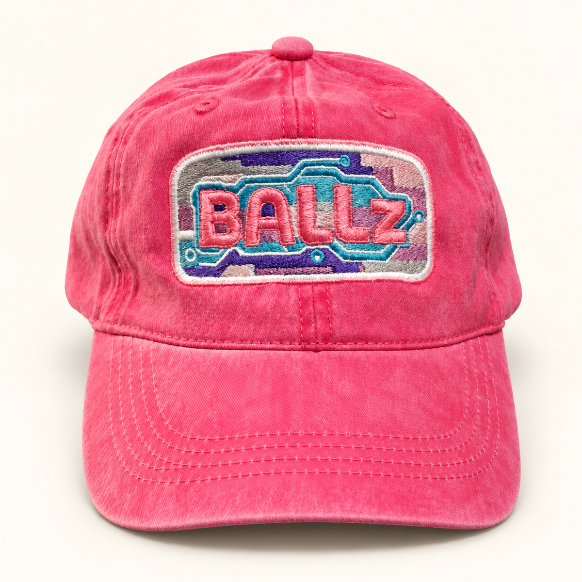 Front view of a hot pink distressed ponytail baseball hat with colorful BALLz embroidery.