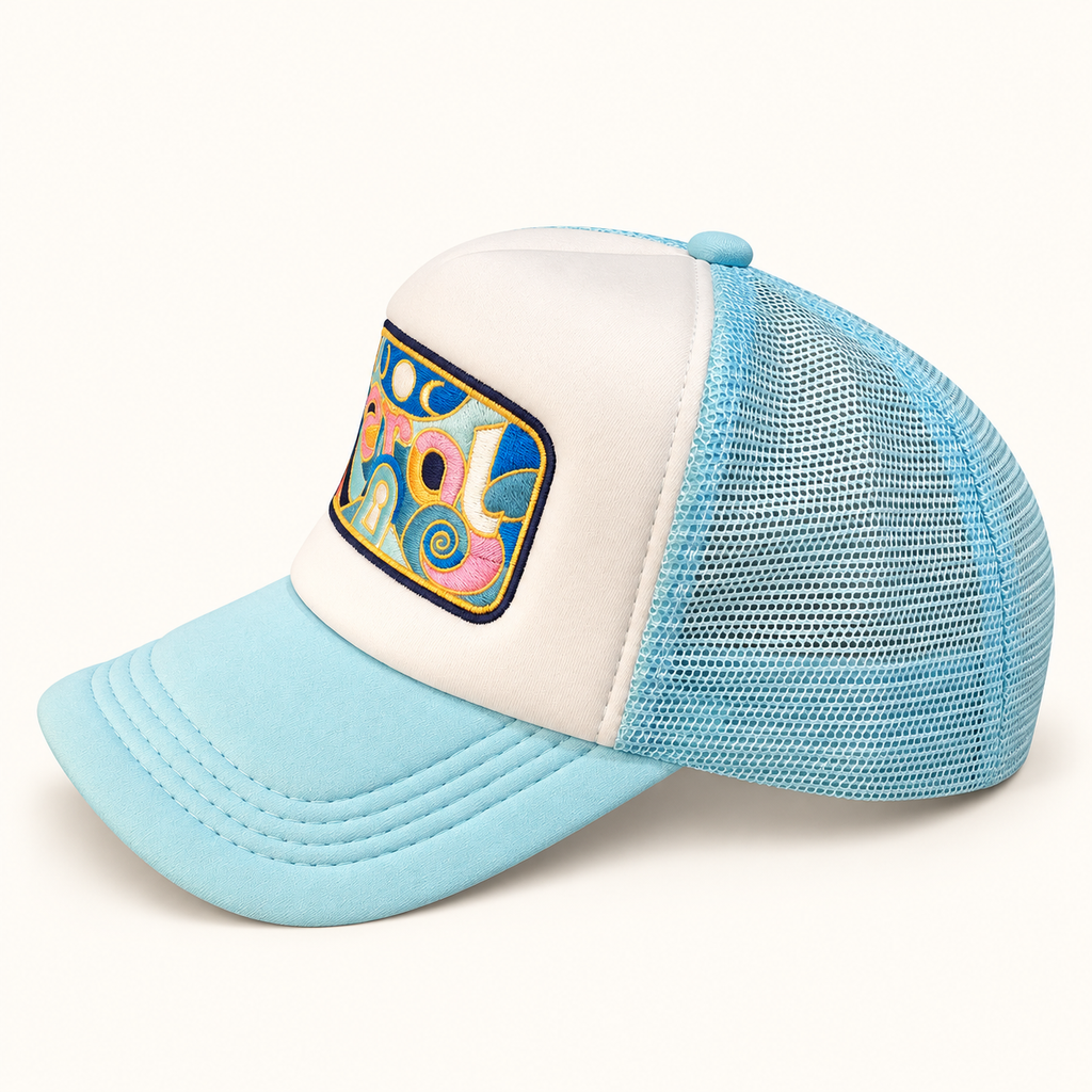 Side profile of the aqua and white FERAL trucker hat showing the embroidered front, curved brim and aqua mesh panels.