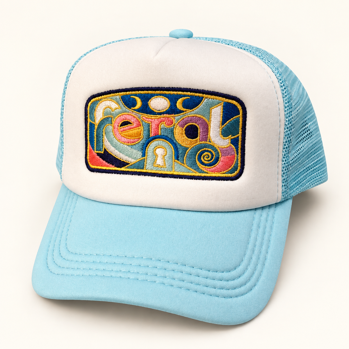 Three-quarter front view of the aqua and white FERAL embroidered trucker hat, showing its curved brim and mesh side.