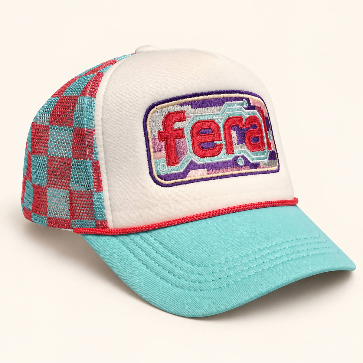 Angled view of a white FERAL cassette embroidered trucker hat with an aqua brim, coral rope, and plaid mesh.