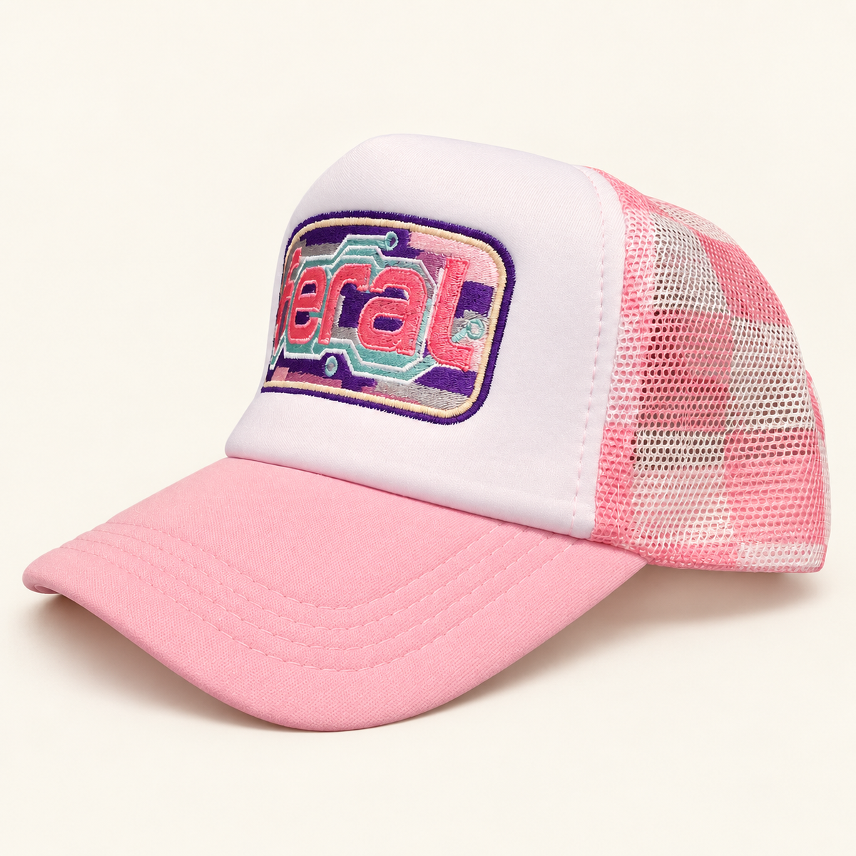 Three-quarter view of the pink plaid FERAL cassette embroidered trucker hat showing the pink brim and checked mesh.