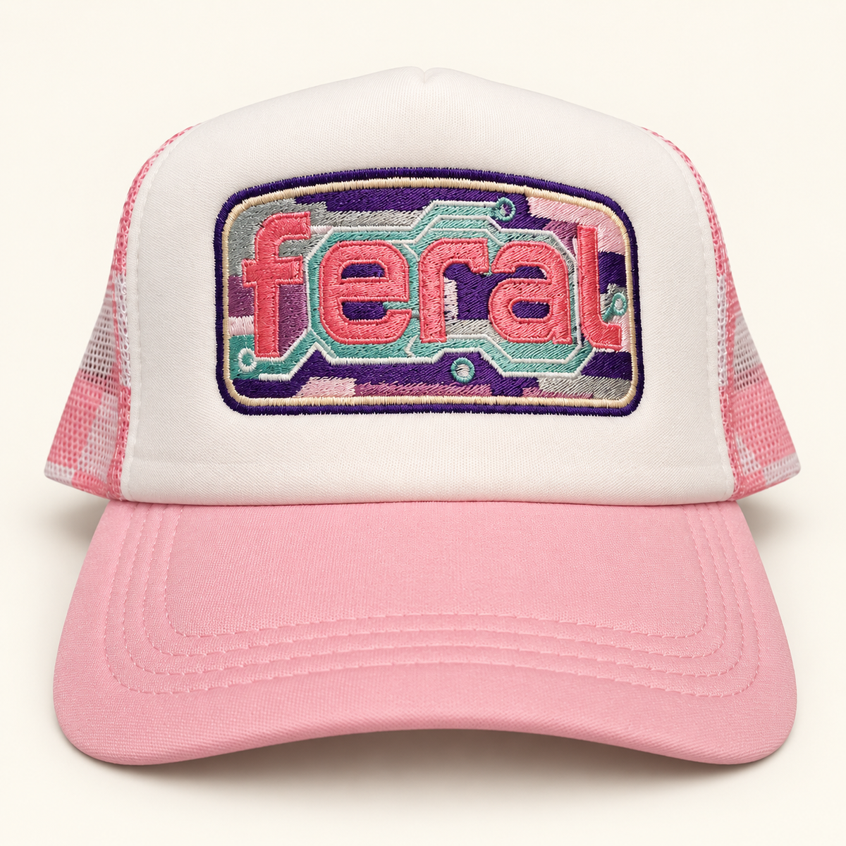 Front view of a white FERAL cassette embroidered trucker hat with a pink brim and plaid mesh.