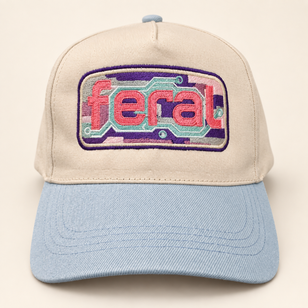 Front view of a cream FERAL cassette embroidered trucker hat with a powder-blue brim.